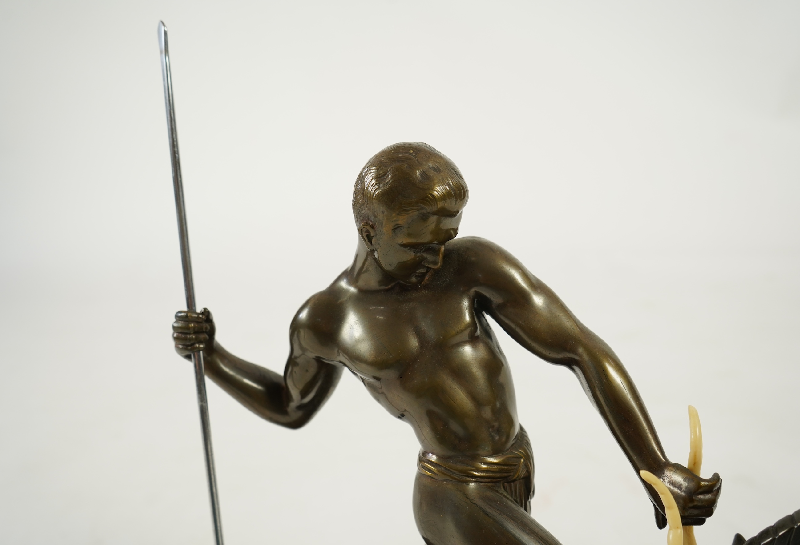 Attributed to Zoltan Kovasz (Romanian, 1883-1952), a bronzed spelter male hunter holding a chromed spear, with springbok, on a polished slate base